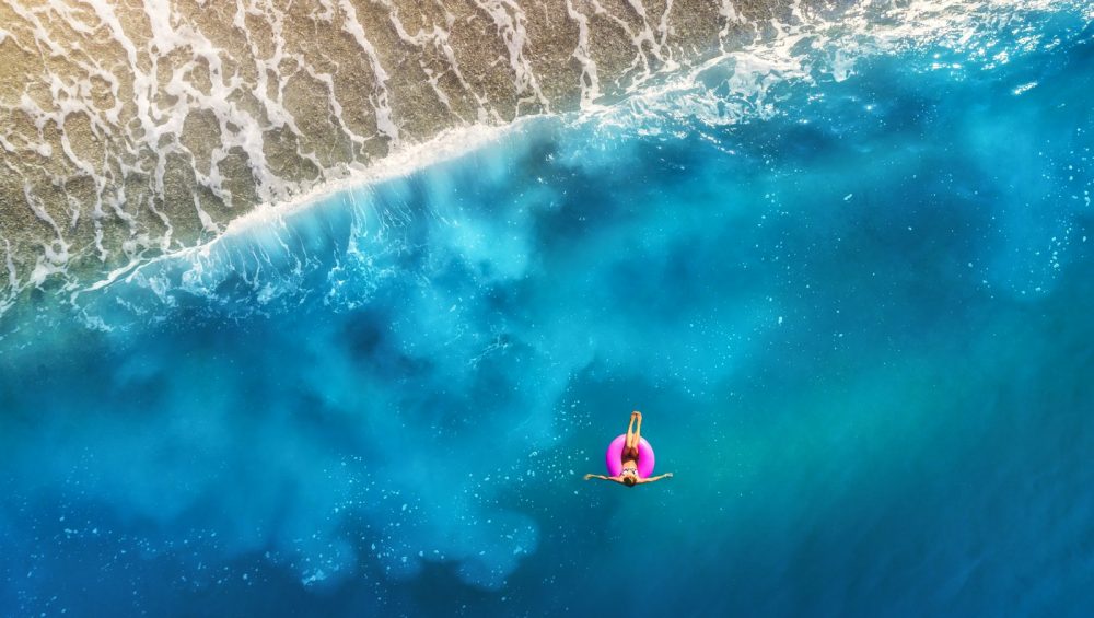 person floating using pink tube