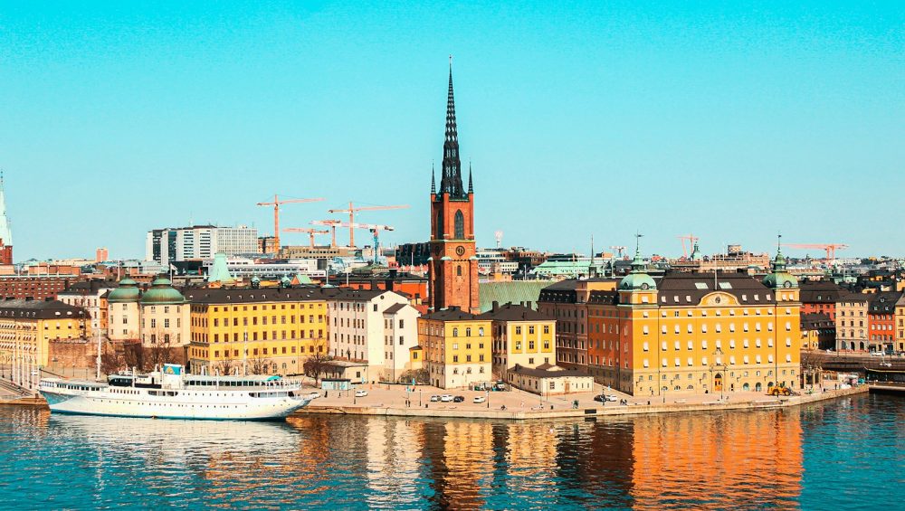 white boat on water near city buildings during daytime